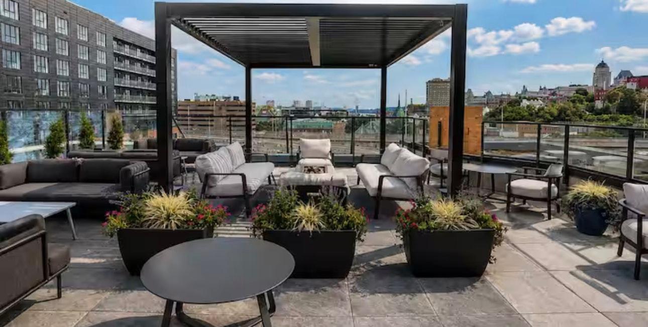 Terrasse avec pergola, canapés extérieurs et bacs de fleurs
